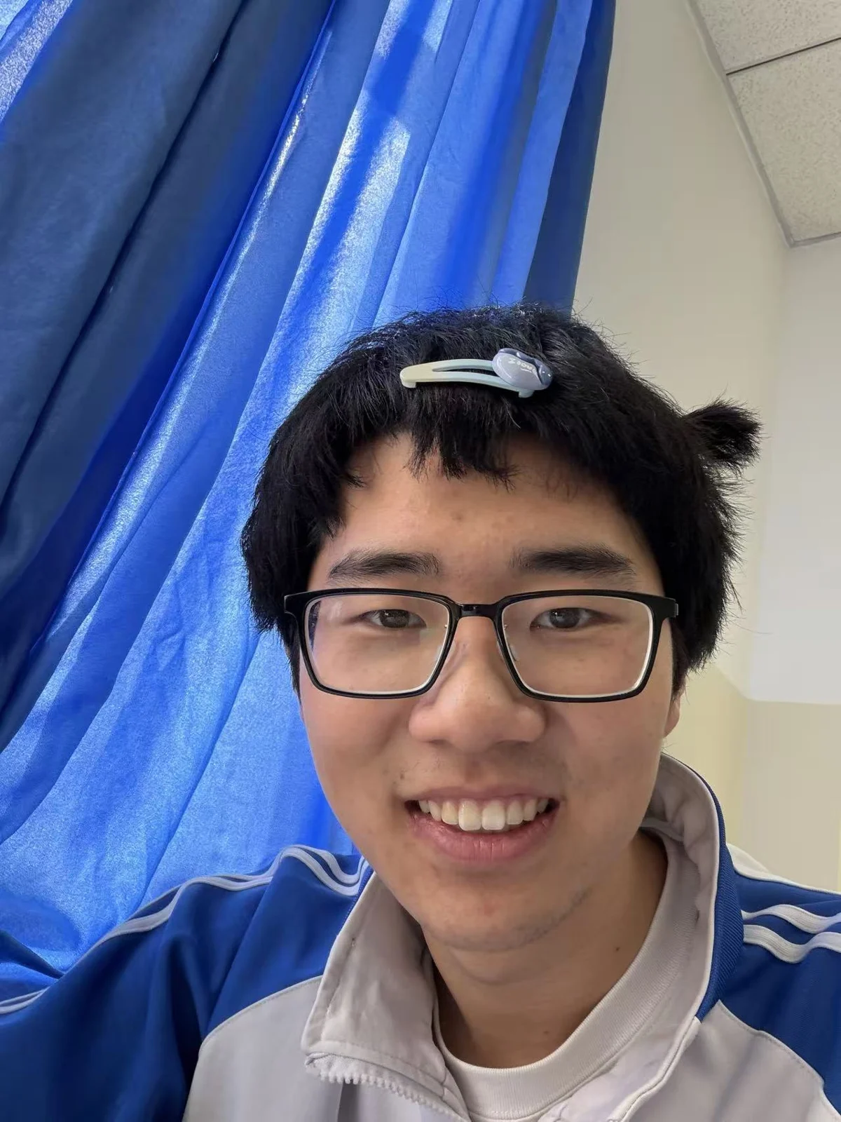 汪子轩戴着眼镜，对着镜头微笑